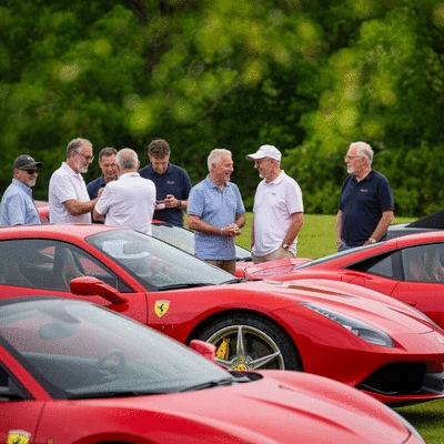 Ferrari Club of America members at a national meet, showcasing various Ferrari models in a vibrant outdoor setting